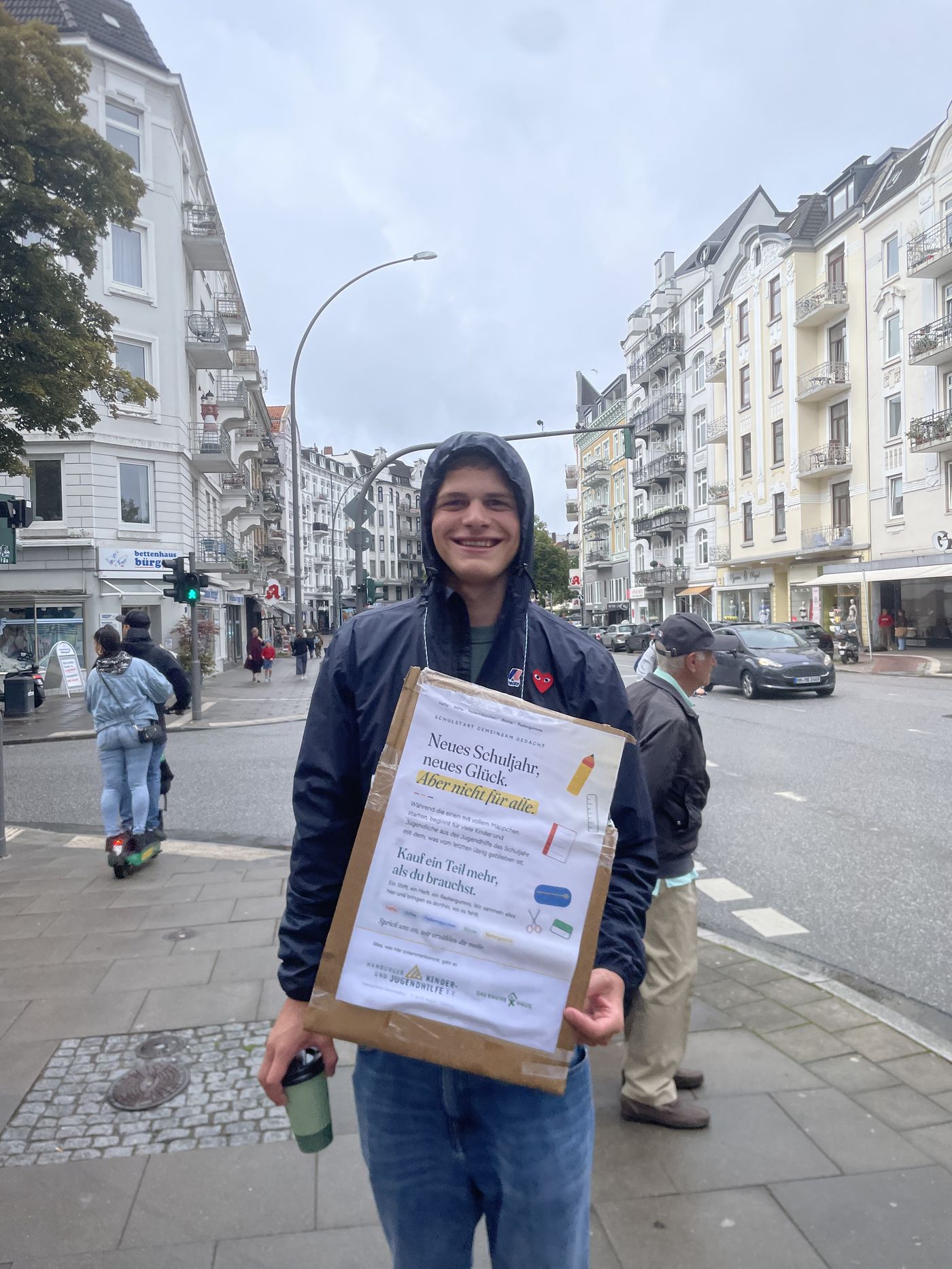 Freiwilliger mit Plakat an der Kreuzung